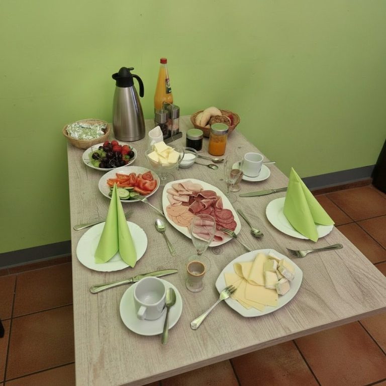 Ein Tisch gedeckt mit verschiedenen Käsesorten, Wurst, frischem Obst und Getränken.